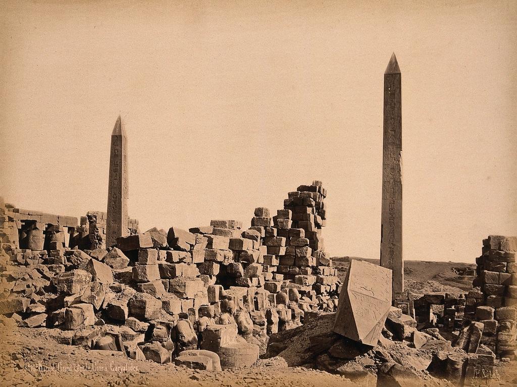 A young person sitting quietly in the temple courtyard, silhouetted against ancient stone